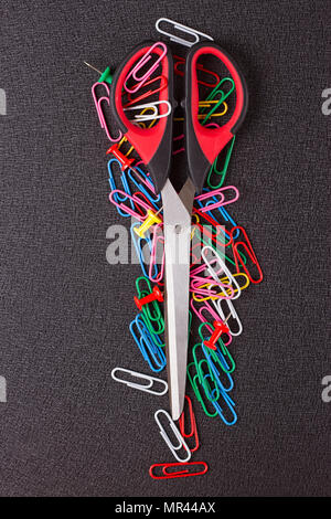 Scissors and paper clips on a black background Stock Photo