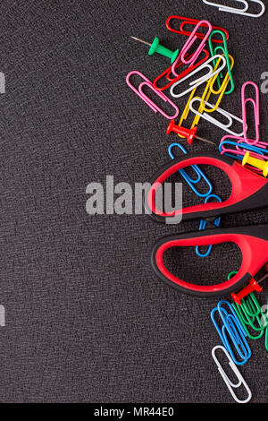 Scissors and paper clips on a black background Stock Photo