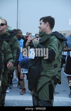 Spc. Cory Brunt, a Soldier with Joint Task Force Atlas (Counter-Improvised Explosive Devices), Combined Joined Task Force-Operation Inherent Resolve, chats with other runners before the Explosive Ordnance Disposal memorial 5k run, May 5, Camp Arifjan, Kuwait. Brunt and three other Soldiers with Task Force Atlas chose to run the 5k in bomb suits to honor other EOD technicians who have fallen. The 5k was held to commemorate and shadow the EOD memorial ceremony held at Eglin Air Force Base, Florida. (U.S. Army photo by Sgt. Kimberly Browne, Army Central Public Affairs) Stock Photo