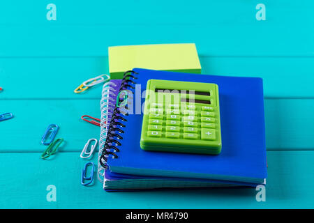 Calculator and pencil on notepad on the blue background Stock Photo