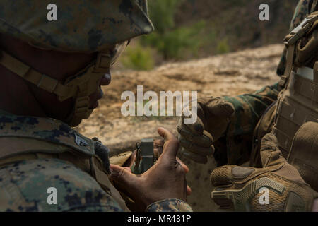 A Marine prepares to remove the first safety clip of an M67 ...