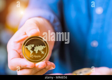 cryptocurrency coins - Ethereum, Litecoin, Bitcoin, Ripple. Women hold the cryptocurrency coin on hand. Physical bitcoins gold and silver coins Stock Photo