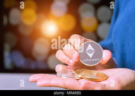 cryptocurrency coins - Ethereum, Litecoin, Bitcoin, Ripple. Women hold the cryptocurrency coin on hand. Physical bitcoins gold and silver coins Stock Photo