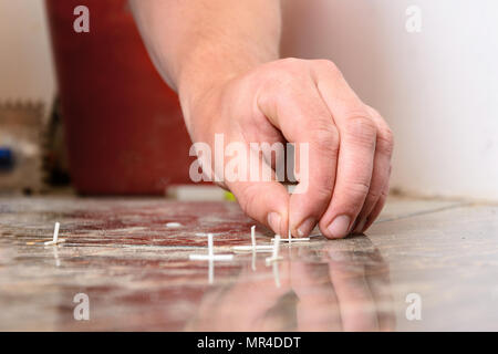 Plastic crosses for laying tiles on the floor are scattered over the tile 2018 Stock Photo