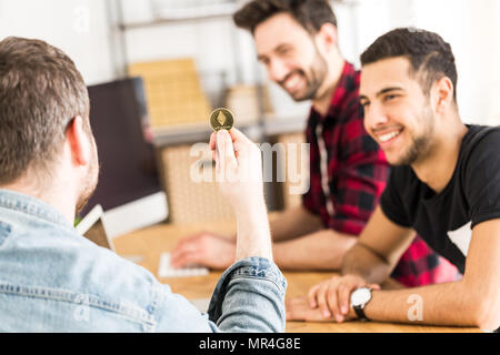 Happy financier with gold coin as a symbol of cryptocurrency. Making money on the Internet Stock Photo