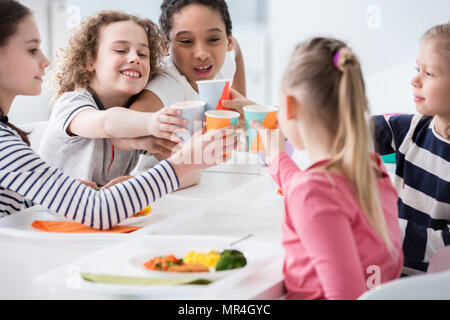 Multicultural group of children toasting during birthday party at home Stock Photo