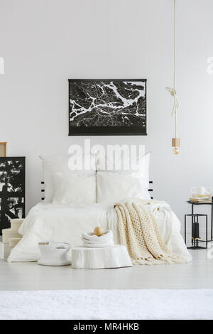 White spacious bedroom interior in scandinavian style with white sheets on the bed Stock Photo