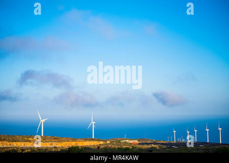 big farm of solar panel and wind mill on the background. green and clean production of electrical energy in tenerife. mountains and beautiful landscap Stock Photo