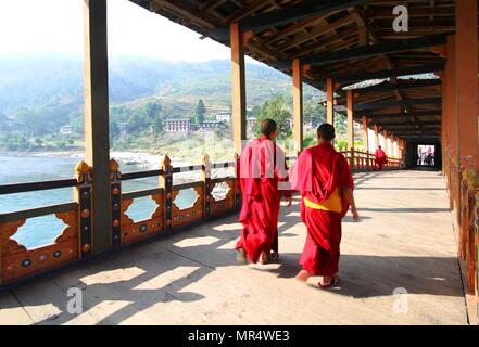 Two young monks walking on  PUNA MOCCHU BAZAM : Antique  wooden bridge at Punakha Dzong Monastery or Pungthang Dewachen Phodrang  Bhutan Stock Photo