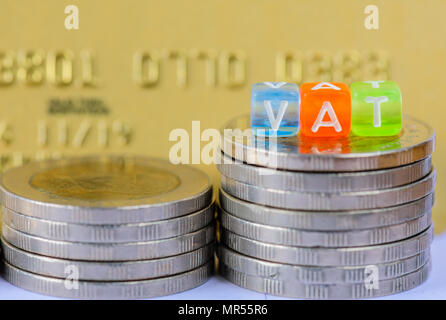 VAT (Value Added Tax) on stacks of  coins with gold credit card background. Stock Photo
