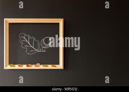 Chalkboard wall with a wooden frame and an acorn painted there Stock Photo