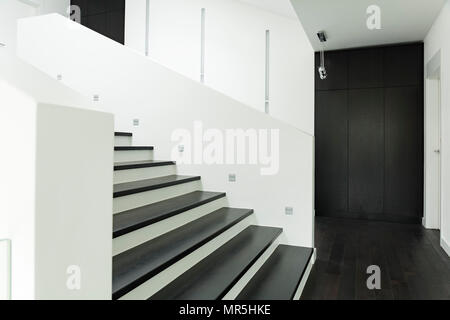 White villa interior with black wardrobe and modern stairs Stock Photo