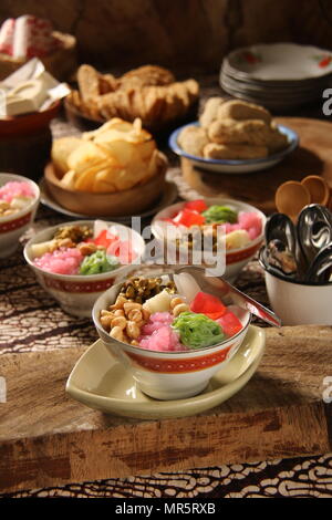 Wedang Angsle. Javanese hot dessert of ginger and coconut soup with various toppings. Accompanied with local, traditional snacks from the area. Stock Photo