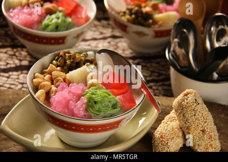 Wedang Angsle. Javanese hot dessert of ginger and coconut soup with various toppings. Accompanied with local traditional snack from the area. Stock Photo