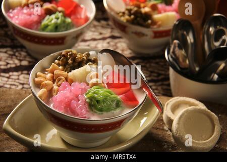 Wedang Angsle. Javanese hot dessert of ginger and coconut soup with various toppings. Accompanied with local traditional snack from the area. Stock Photo