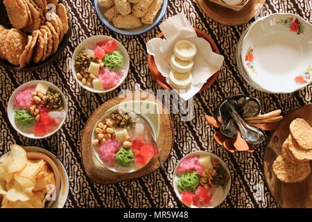 Wedang Angsle. Javanese hot dessert of ginger and coconut soup with various toppings. Accompanied with local, traditional snacks from the area. Stock Photo