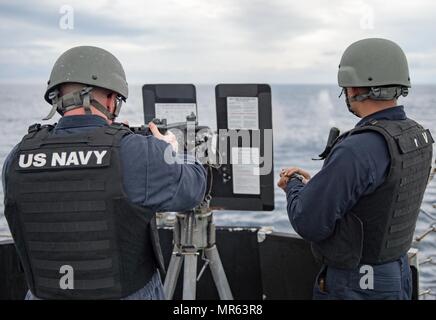 170517-N-HI376-026 WATERS SOUTH OF JAPAN (May 17, 2017) Fire Controlman 2nd Class Nhut Truong Nguyen, right, observes Chief Gunner’s Mate Christopher Davy, left, as he fires a .50 caliber machine gun during live-fire training aboard the forward-deployed Arleigh Burke-class guided-missile destroyer USS McCampbell (DDG 85). McCampbell is on patrol in the U.S. 7th Fleet area of operations in support of security and stability in the Indo-Asia-Pacific region. (U.S. Navy photo by Mass Communication Specialist 2nd Class Jeremy Graham/Released) Stock Photo