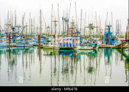 Newport, Oregon,USA - August 23, 2016:  Slowly lifting fog above commercial fishing boats in New Port Harbor on the Oregon Coast Stock Photo