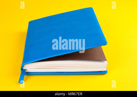 Blue closed diary on a yellow background Stock Photo
