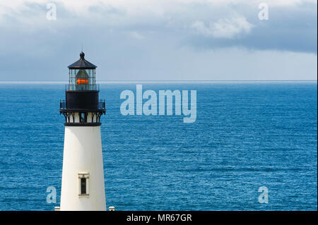 Copyspace is available in this minimalist of the upper portion of Yaquina Head Lighthouse with the background of clouds meeting the sea of the Pacific Stock Photo