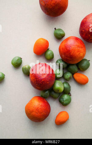 Varitety of fresh summer fruits on neutral background with mini kiwis and red oranges Stock Photo