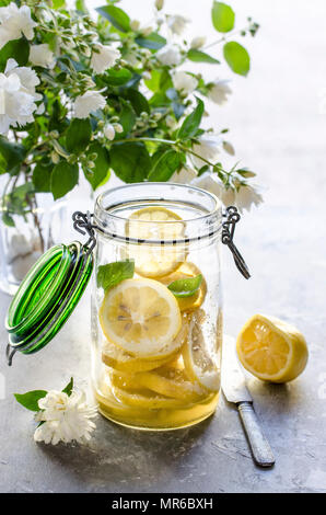 Making preserved lemon. Sliced fresh lemons in a jar. Stock Photo