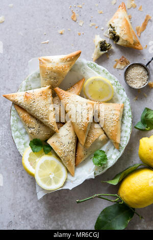 Spanakopita triangles or spinach pie is a Greek savoury pastry. Ingredients include spinach, feta cheese, onions and eggs. Stock Photo