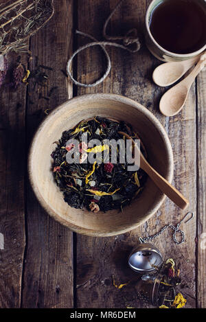 Herbal dry tea leaves with wild flowers and dried fruit on wooden rustic table. Top view Stock Photo