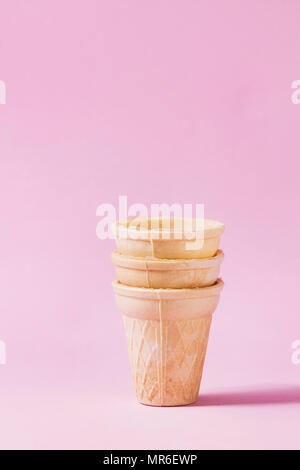 Stack of empty waffle cups for ice cream over pink pastel pin-up background. Copy space. Stock Photo
