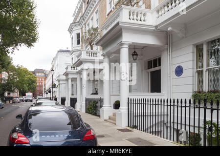 Upmarket stucco terrace townhouses with portico facades with a parked Porsche on the street in Onslow Gardens, Kensington, London, England, UK Stock Photo