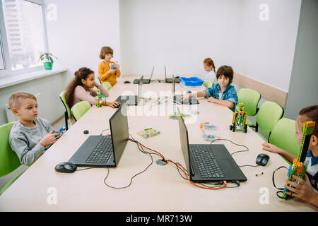 group of serious kids working with computers on machinery class Stock Photo