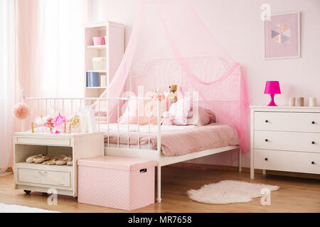 Cozy child bedroom in pink with canopy bed and dresser Stock Photo