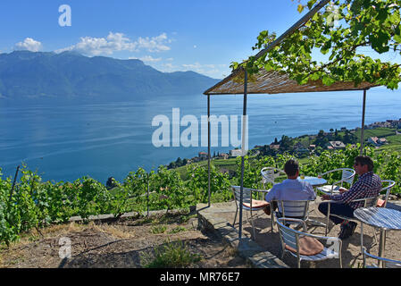 Two patrons enjoying a glass of wine and view over Lake Geneva, Chexbres, Switzerland Stock Photo
