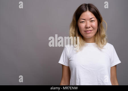 Young beautiful Kazakh woman against gray background Stock Photo