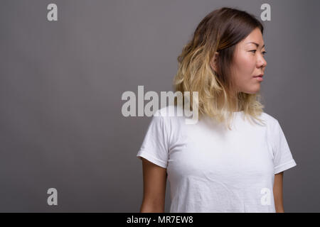 Young beautiful Kazakh woman against gray background Stock Photo