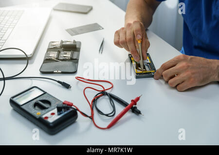 smartphone repairs - technician repairing defective phone Stock Photo