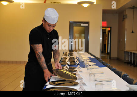 Specialist Leon Van, a food service specialist with the 3rd Expeditionary Sustainment Command, prepares a dining room for the Culinary Arts Cook-off May 22, 2017 at the Culinary Arts Training Center at Fort Bragg, N.C.    The Culinary Arts Cook-off is a recent addition to the All American Week traditions. Currently in its third year, the cooking competition pits small teams of Paratroopers from different dining facilities against each other in a television-show worthy cook off. Each team presents a four-course meal to the 82nd Airborne Division leaders and they vote to determine which dining f Stock Photo