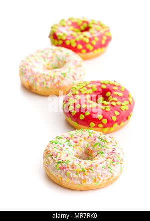 Sweet sprinkled donuts isolated on white background. Stock Photo