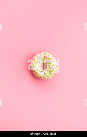 Sweet sprinkled donut on pink background. Stock Photo