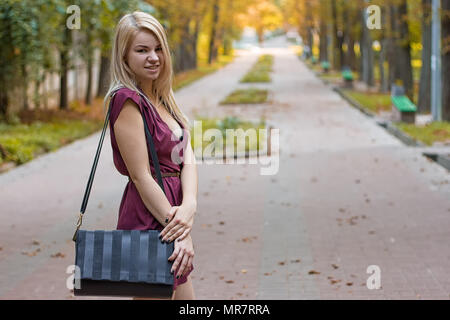 girl dressed in a dress on the autumn alley Stock Photo