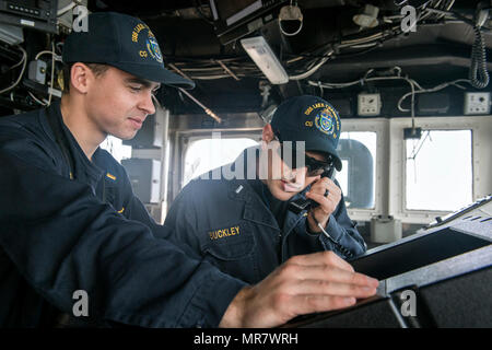 170524-N-FT178-015 WESTERN PACIFIC (May 24, 2017) Ens. John Taiclet, from St. Louis, left and Lt. j.g. Jason Buckley, from Wildwood, Mo., check for clear range before a pre-aim calibration fire exercise aboard Ticonderoga-class guided-missile cruiser USS Lake Champlain (CG 57). The U.S. Navy has patrolled the Indo-Asia-Pacific routinely for more than 70 years promoting regional peace and security. (U.S. Navy photo by Mass Communication Specialist 2nd Class Nathan K. Serpico/Released) Stock Photo