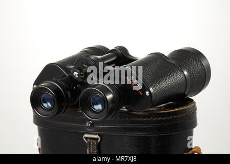 Retro binoculars (field glasses) and old-fashioned leather case isolated on a white background. Stock Photo