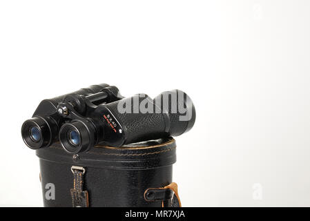 Retro binoculars (field glasses) and old-fashioned leather case isolated on a white background. Stock Photo