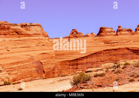 View form the lower Delicate Arch Trail in the Arches National Park Moab Utah.  Show the steady stream of tourists making the pilgrimage  to the Arch Stock Photo