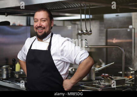 Food concept. A young cook stands in the kitchen. Stock Photo