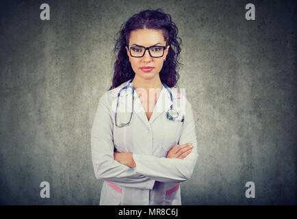 Beautiful woman in glasses wearing white apparel of doctor and stethoscope looking confidently at camera. Stock Photo