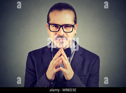 Sly business man in glasses looking at camera plotting a revenge Stock Photo