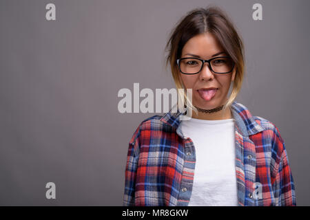 Young beautiful Kazakh woman against gray background Stock Photo