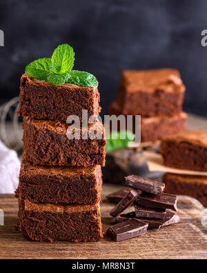 square pieces of baked brownie lie in a pile on a wooden table, close up Stock Photo