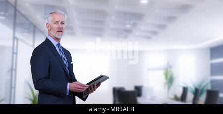 Portrait of senior businessman using tablet in front of his modern office Stock Photo